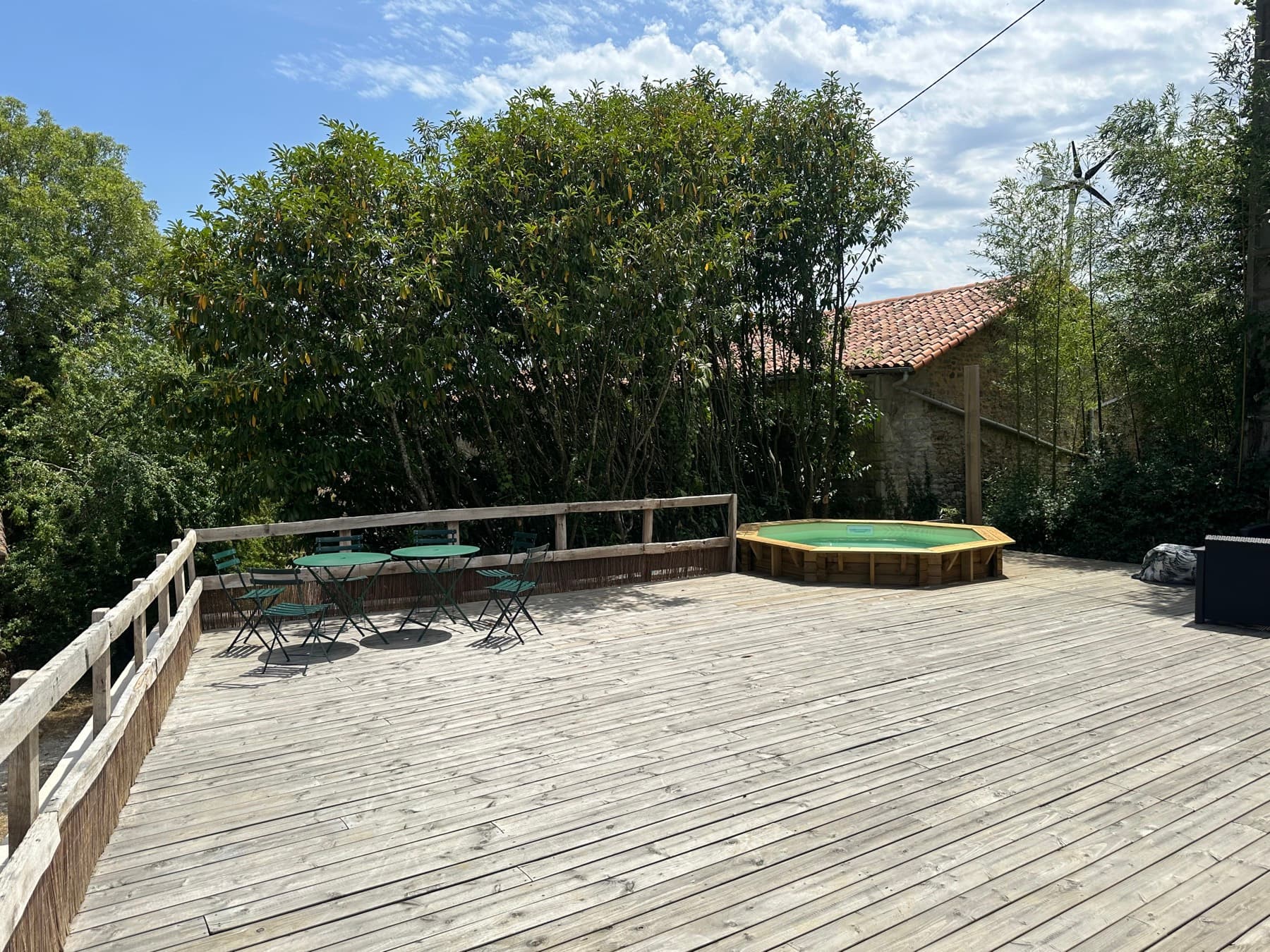 La grande terrasse en bois et le bassin